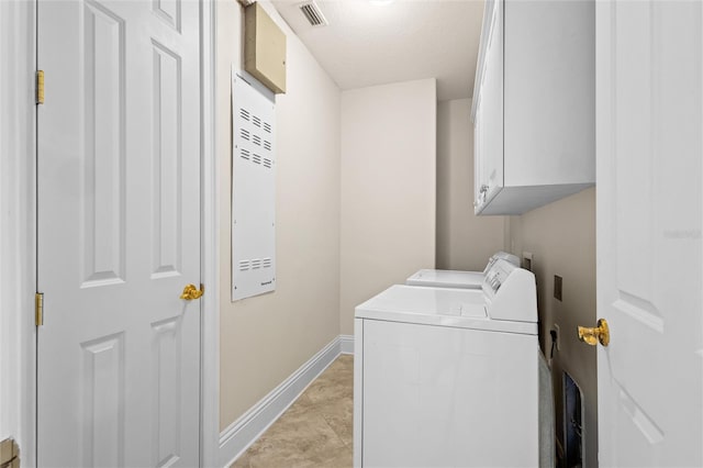 laundry area with cabinets, light tile patterned floors, and washing machine and clothes dryer