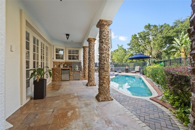 view of pool with area for grilling, grilling area, and a patio