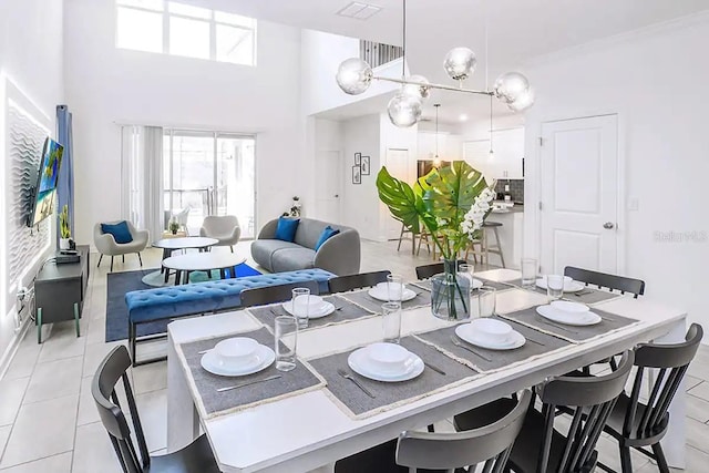 tiled dining area featuring a chandelier, crown molding, and a towering ceiling