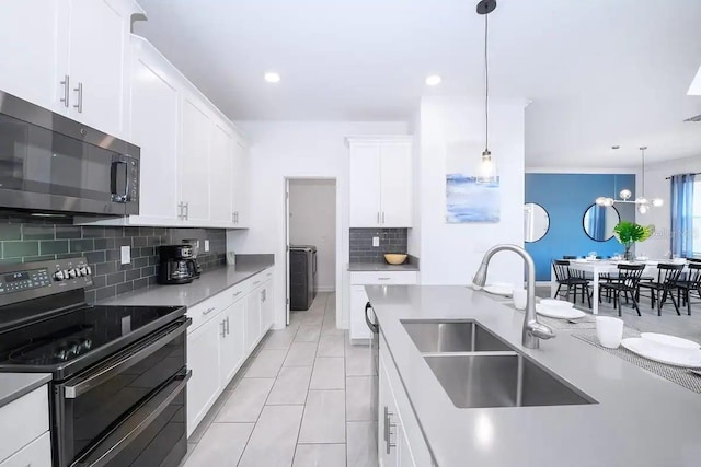 kitchen featuring decorative light fixtures, white cabinetry, double oven range, sink, and light tile patterned floors