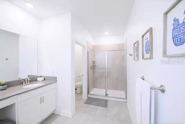 bathroom with toilet, vanity, tile patterned flooring, and a shower with shower door