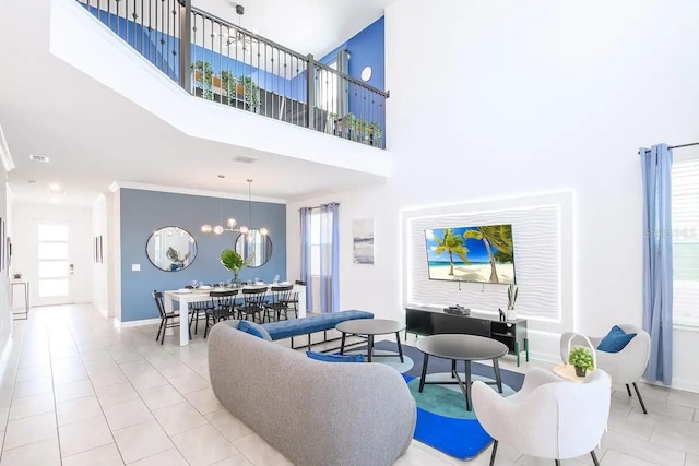 living room featuring a towering ceiling, light tile patterned floors, crown molding, and a notable chandelier