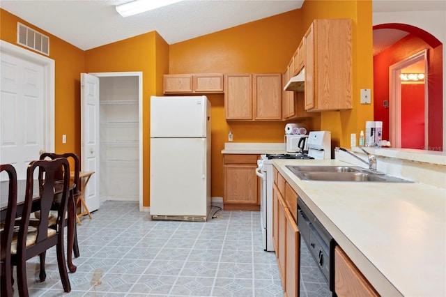 kitchen with light brown cabinetry, sink, white appliances, and vaulted ceiling