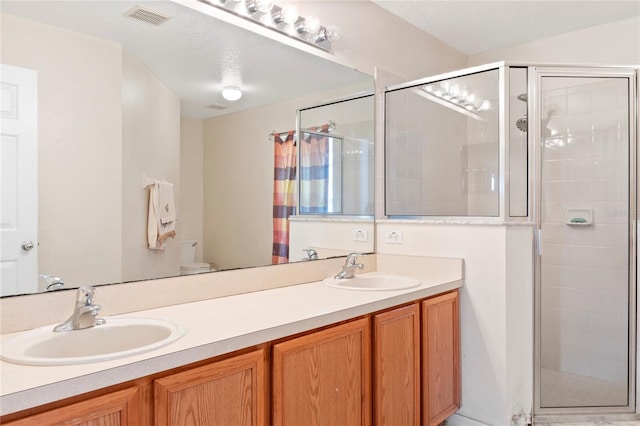 bathroom featuring vanity, toilet, and an enclosed shower