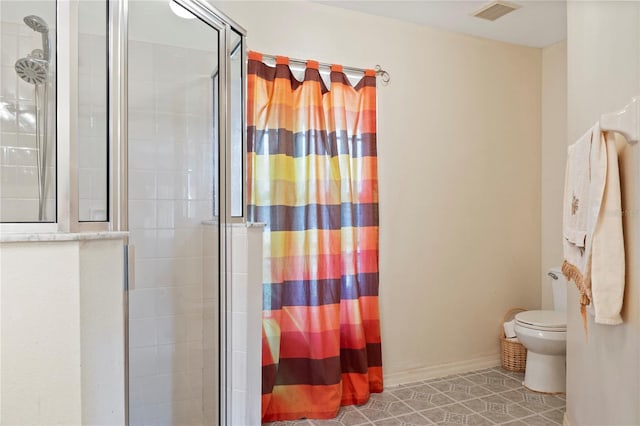 bathroom with toilet, an enclosed shower, and tile patterned floors