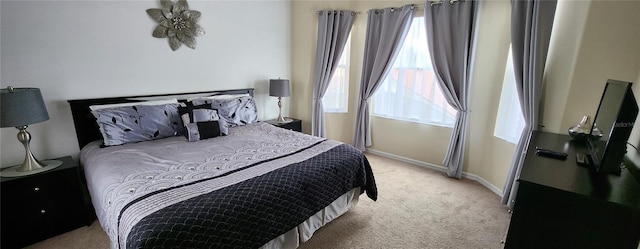 bedroom featuring multiple windows and light colored carpet