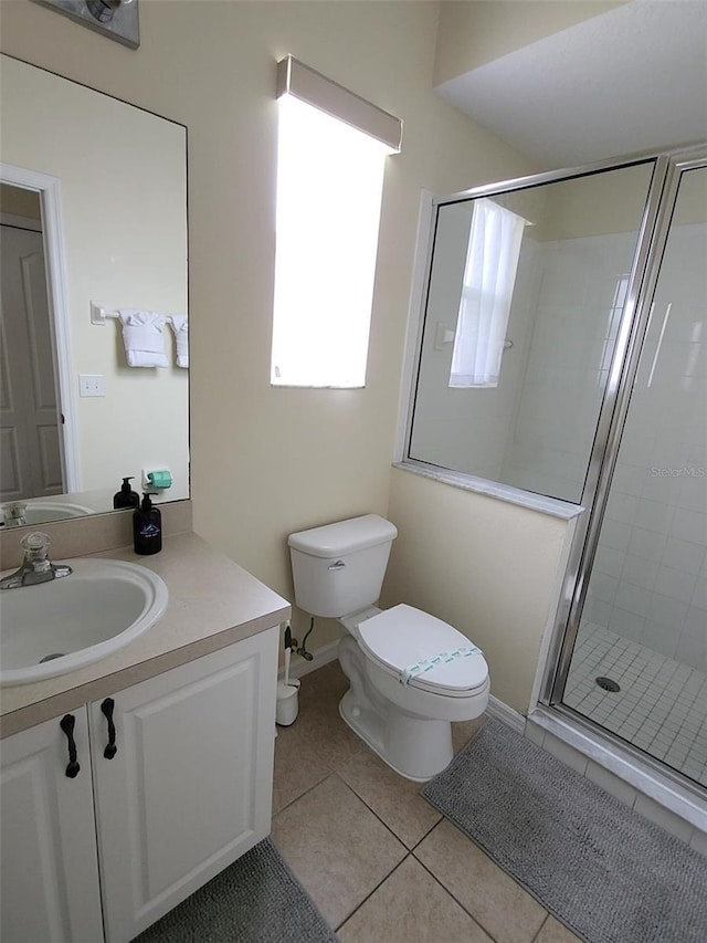 bathroom featuring an enclosed shower, vanity, tile patterned floors, and toilet