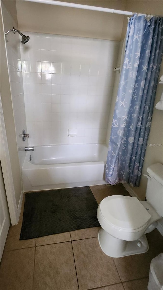 bathroom with toilet, tile patterned floors, and shower / bath combo with shower curtain