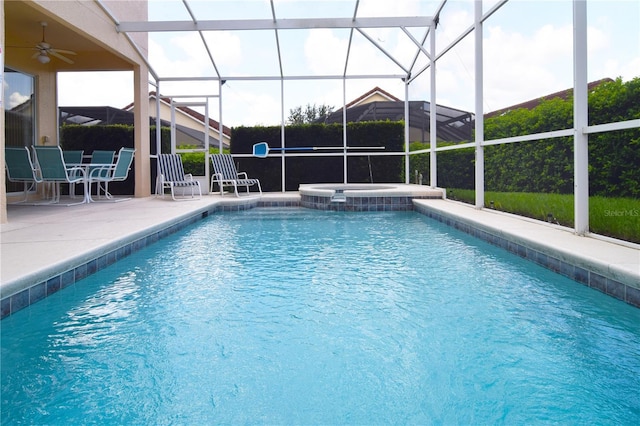 view of swimming pool with an in ground hot tub, a patio, ceiling fan, and glass enclosure