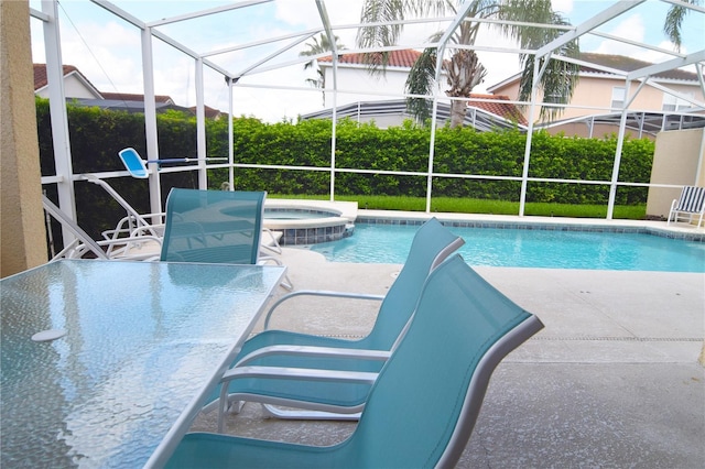 view of swimming pool with an in ground hot tub, glass enclosure, and a patio area