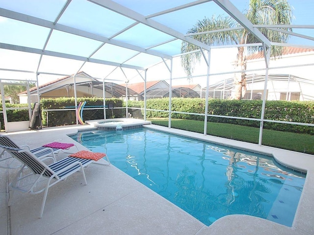 view of pool with an in ground hot tub, glass enclosure, and a patio