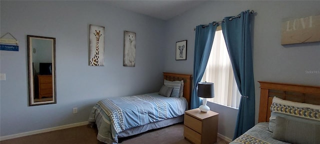 bedroom featuring multiple windows and dark colored carpet