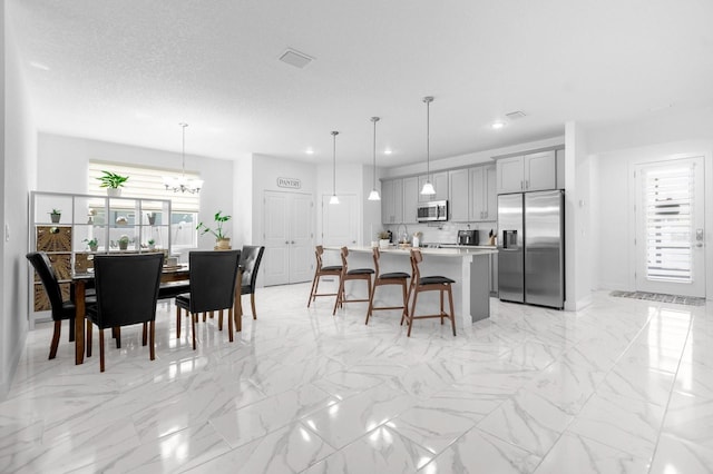 dining area with a chandelier, a textured ceiling, and sink