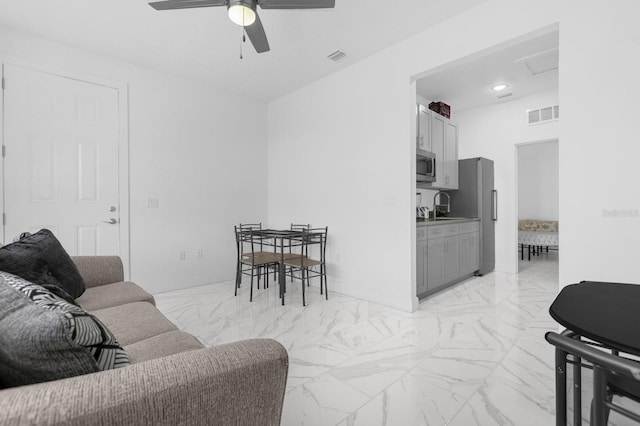 living room with ceiling fan and sink