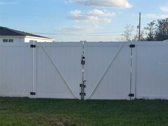 view of gate featuring a lawn