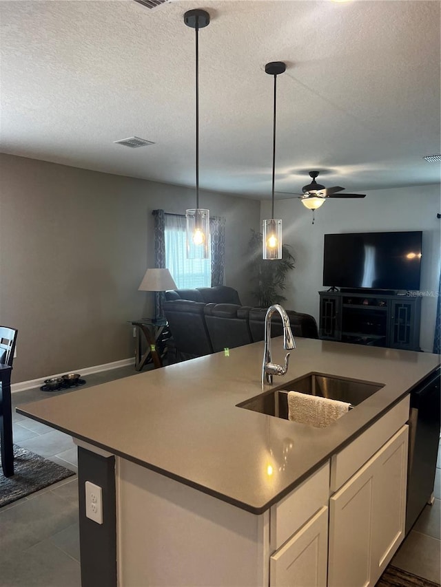 kitchen with dishwasher, white cabinetry, sink, ceiling fan, and a center island with sink