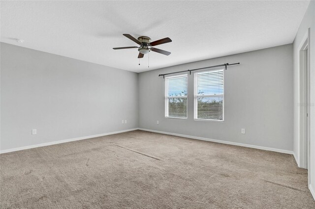 carpeted spare room featuring a textured ceiling and ceiling fan