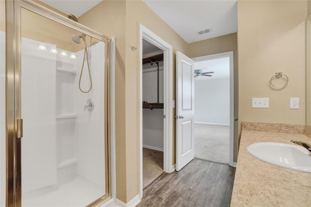 bathroom with an enclosed shower, vanity, hardwood / wood-style flooring, and ceiling fan