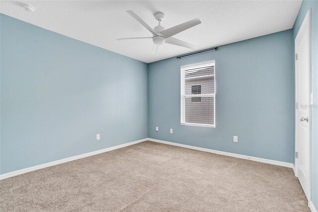 carpeted spare room featuring ceiling fan and a textured ceiling