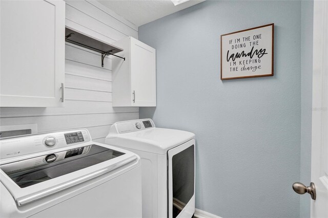 laundry area with washer and clothes dryer and cabinets