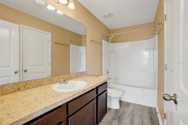 full bathroom featuring hardwood / wood-style floors, vanity, toilet, and shower / bathtub combination