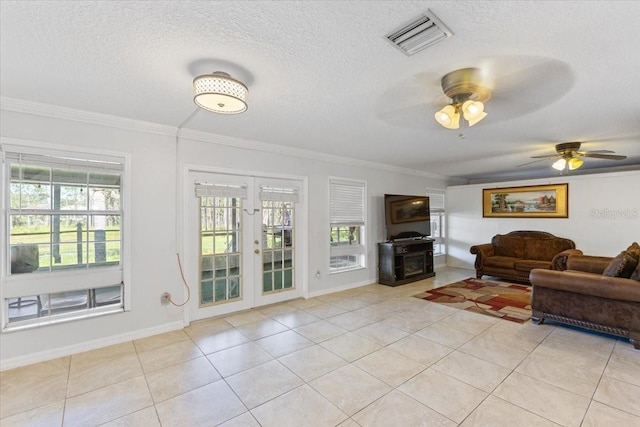 living room with french doors, crown molding, a textured ceiling, and light tile patterned floors