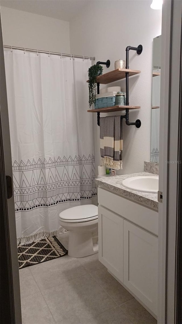 bathroom featuring tile patterned floors, vanity, and toilet