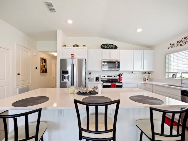 kitchen featuring sink, white cabinets, appliances with stainless steel finishes, and a center island