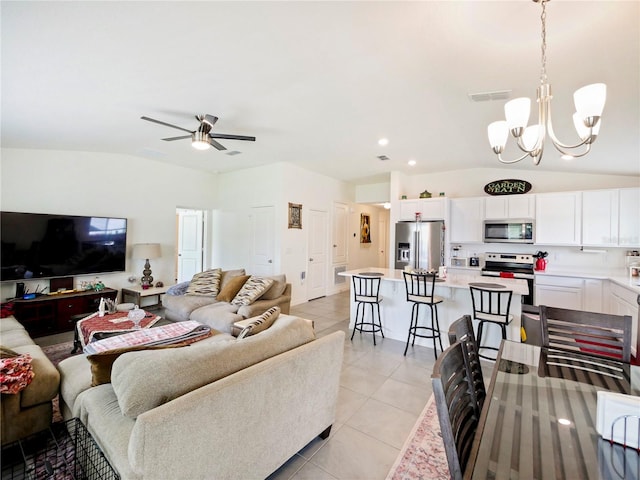 tiled living room with ceiling fan with notable chandelier and lofted ceiling