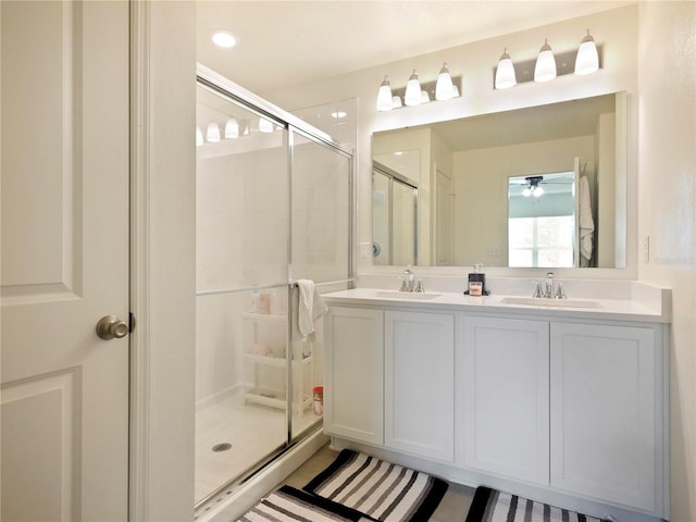 bathroom with a shower with shower door and vanity