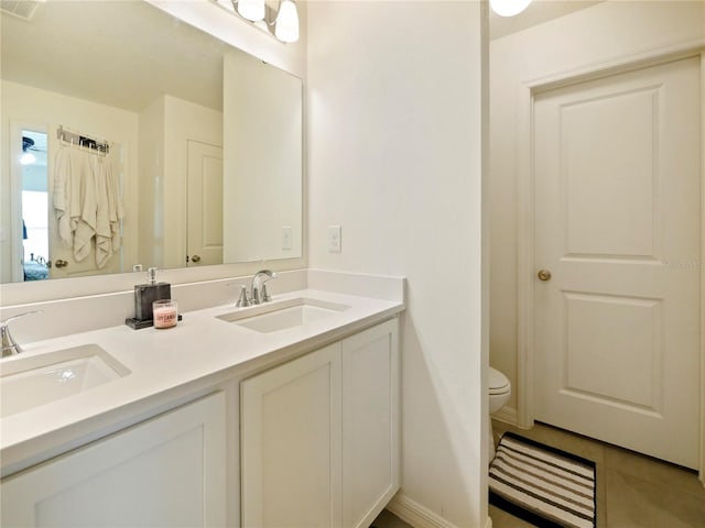 bathroom with toilet, vanity, and tile patterned floors