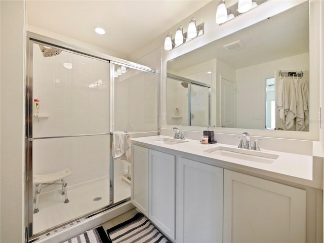 bathroom featuring a shower with shower door, tile patterned floors, and vanity