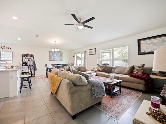 living room with ceiling fan with notable chandelier and light tile patterned floors