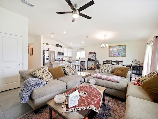 tiled living room with lofted ceiling and ceiling fan with notable chandelier