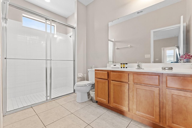 bathroom with vanity, toilet, a shower with door, and tile patterned floors