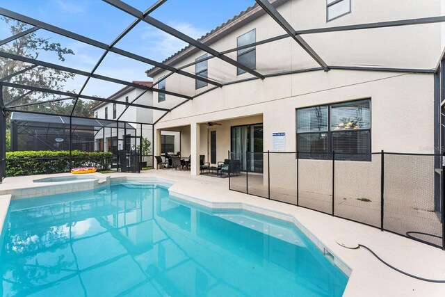 view of swimming pool featuring an in ground hot tub, a lanai, a patio area, and ceiling fan