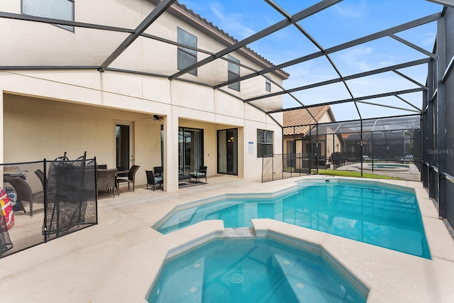 view of pool with an in ground hot tub, a lanai, a patio area, and ceiling fan