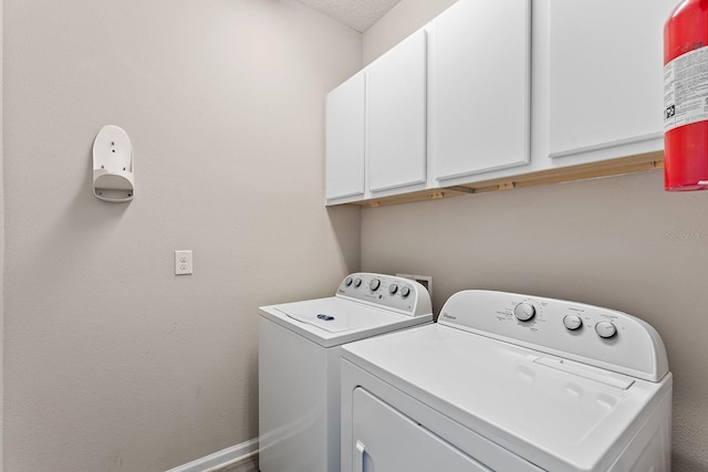 laundry area with independent washer and dryer and cabinets