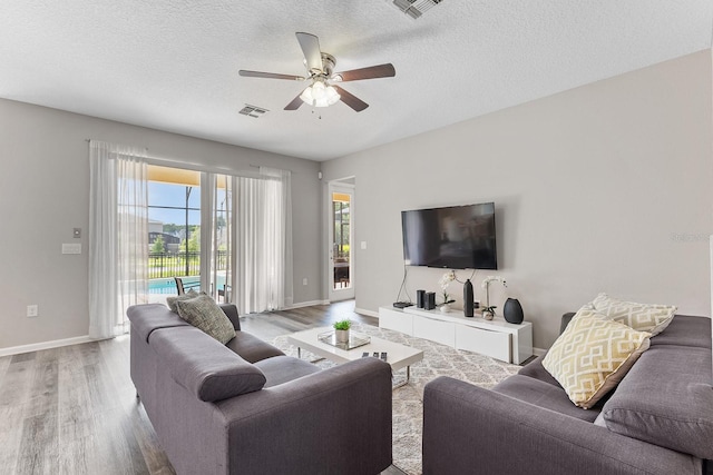 living room featuring a textured ceiling, ceiling fan, and hardwood / wood-style floors