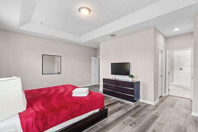 bedroom with a raised ceiling and hardwood / wood-style floors