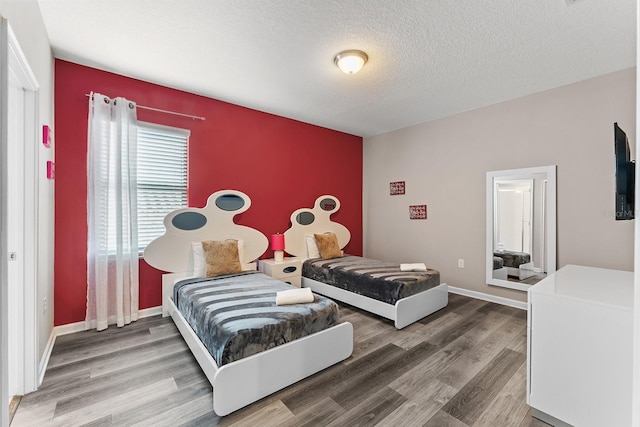 bedroom with a textured ceiling and hardwood / wood-style flooring