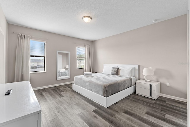 bedroom with a textured ceiling and dark hardwood / wood-style flooring