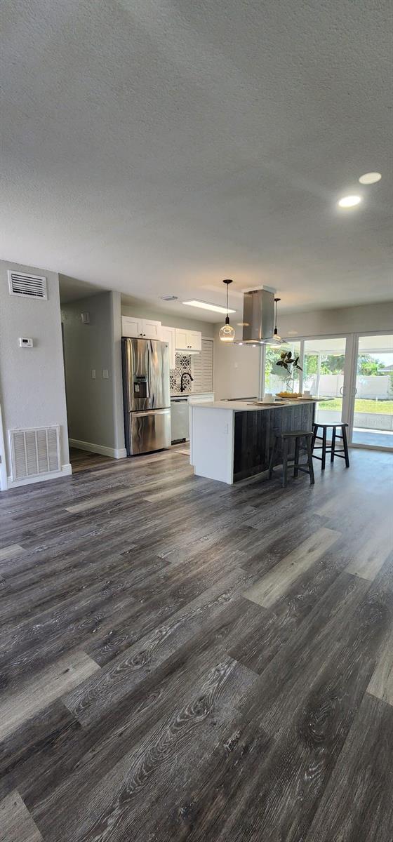 unfurnished living room with dark wood-type flooring and a textured ceiling