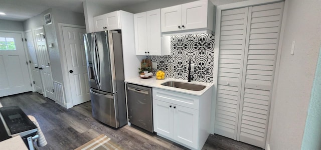 kitchen with decorative backsplash, appliances with stainless steel finishes, dark wood-type flooring, and white cabinetry