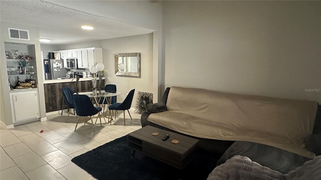 tiled living room featuring a textured ceiling