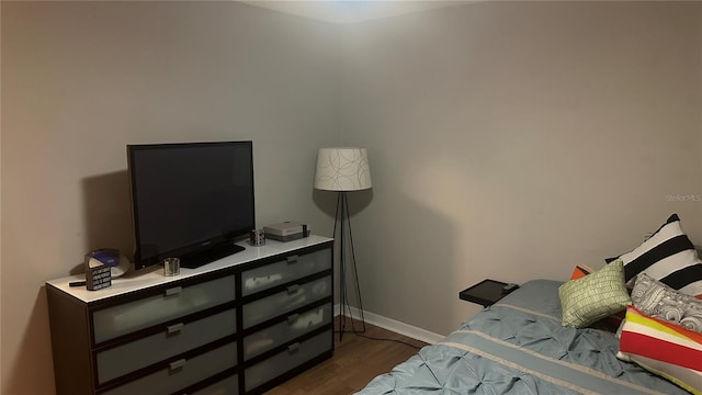 bedroom with dark hardwood / wood-style flooring