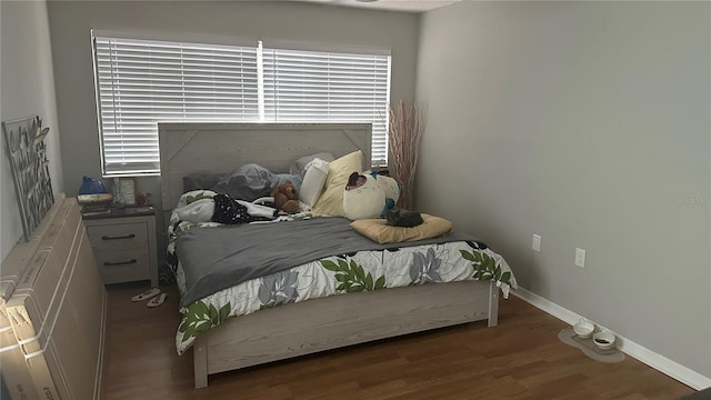 bedroom with dark wood-type flooring