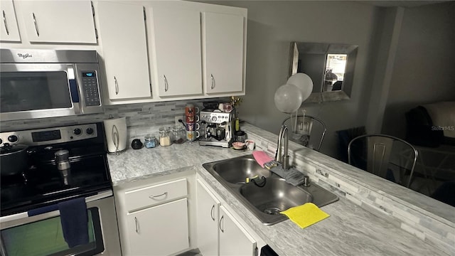 kitchen featuring white cabinets, appliances with stainless steel finishes, sink, and tasteful backsplash