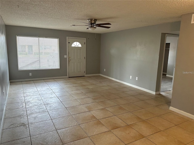 tiled foyer with a textured ceiling and ceiling fan