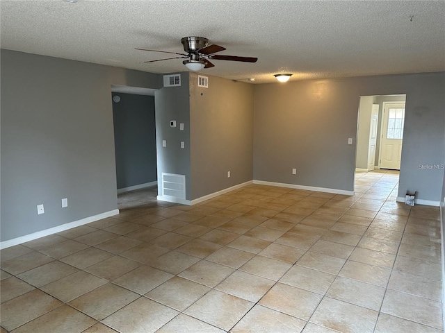 spare room featuring light tile patterned floors, a textured ceiling, and ceiling fan